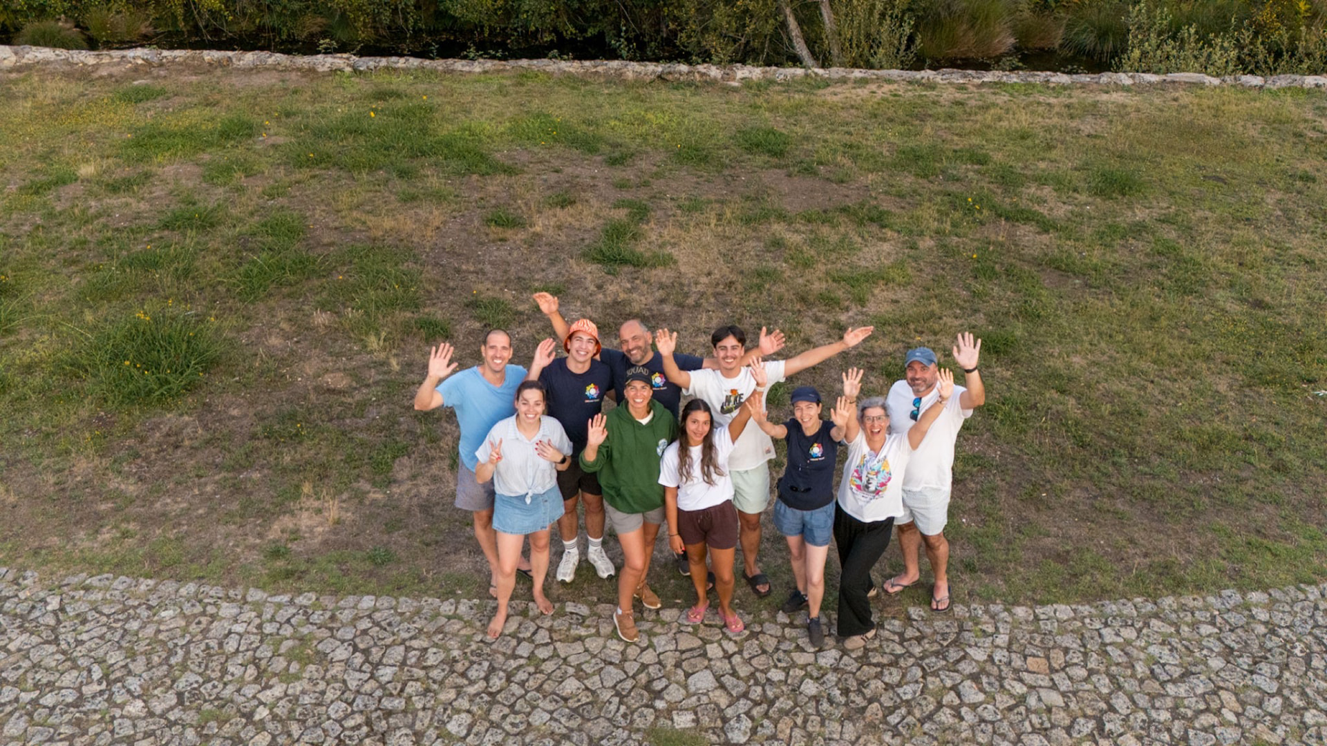 Equipa reunida ao ar livre a acenar durante um encontro